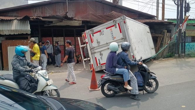 
					Hindari Avanza, Mobil Box Terbalik dan Rusak Gudang Kusen di Kemang